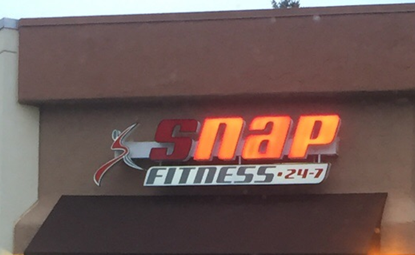 Neon "Snap Fitness" sign. The letters N A and P are lit up, followed by "Fitness"